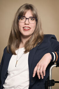 Vanessa Leuthold sitzt lächelnd auf ihrem Rollstuhl, sie lebt mit einer cerebralen Bewegungsbehinderung