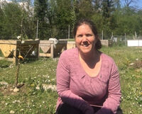 Eva Zurlinden sitzt in ihrem Garten, sie lebt mit einer Hemiparese und hat ein Kind mit Behinderungen