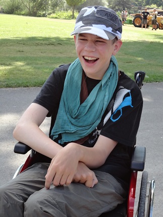 Ein Mitglied sitzt im Rollstuhl und strahlt Lebensfreude aus.