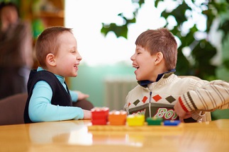 Zwei Jungs spielen gemeinsam im Kindergarten. Der eine lebt mit einer cerebralen Bewegungsbehinderung, der andere ist nichtbehindert.
